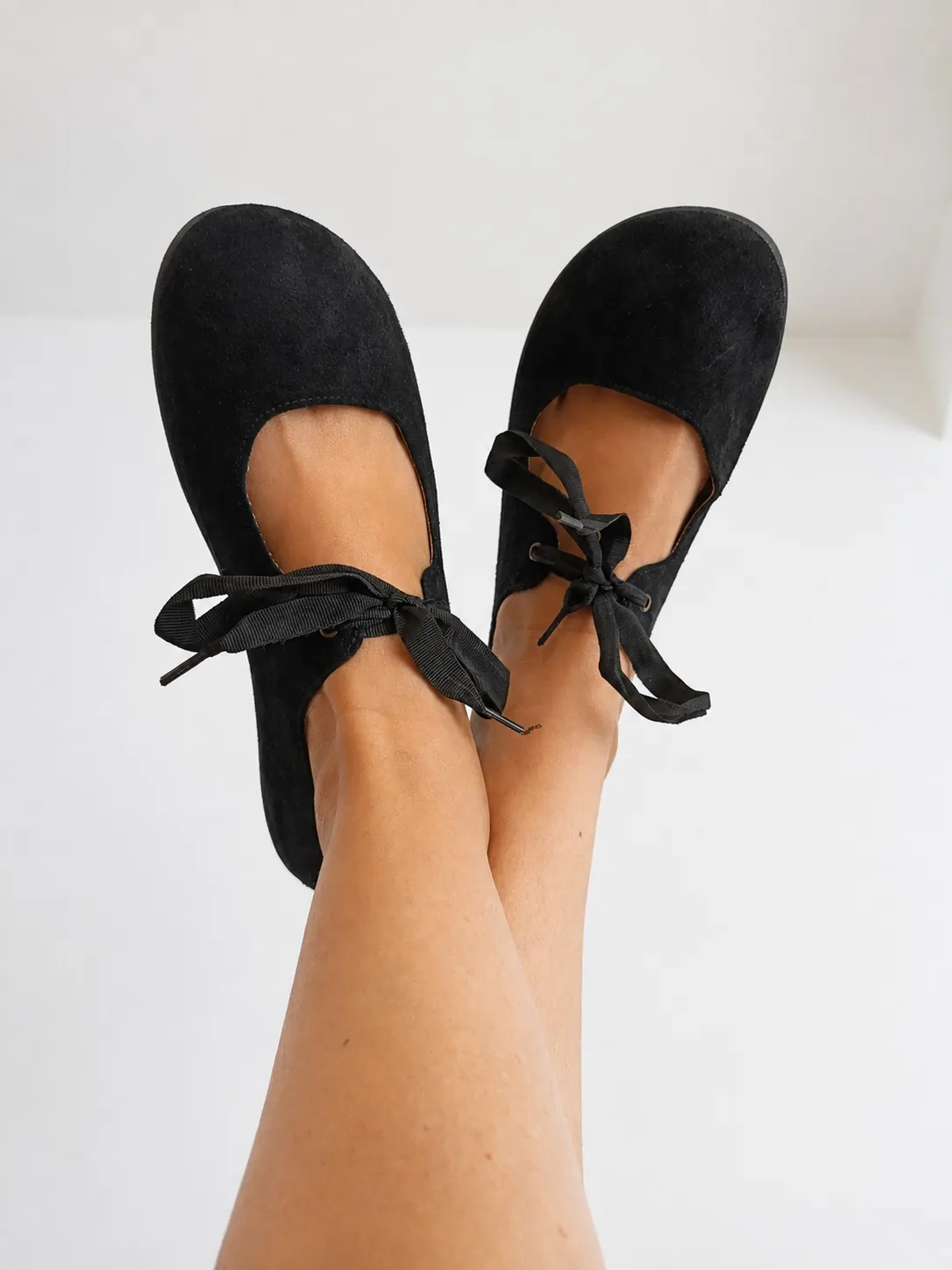 Bailarina barefoot Batilas Angelito en serraje negro puesta, cordones de lazo atados
