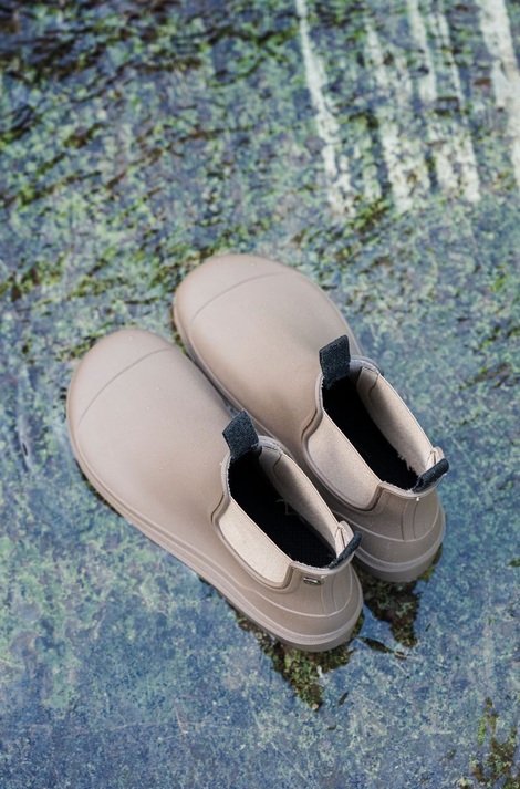 Par de botas de agua Igor Alex en color topo con elástico lateral, foto de estilo de vida junto al agua