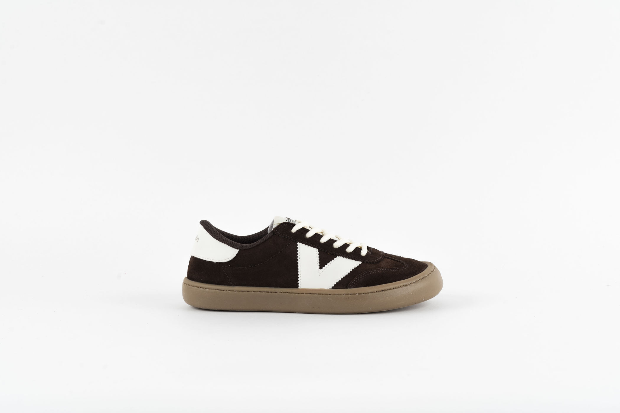 Zapatilla Victoria Barefoot en ante chocolate con logo en V blanco y suela caramelo, vista lateral