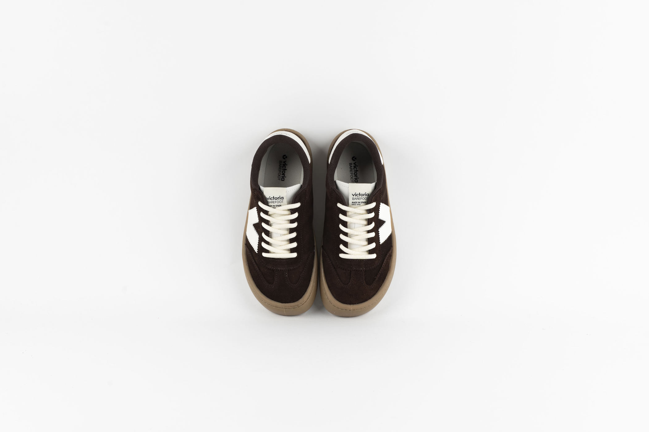 Vista superior de las zapatillas Victoria Barefoot en ante chocolate con cordones blancos